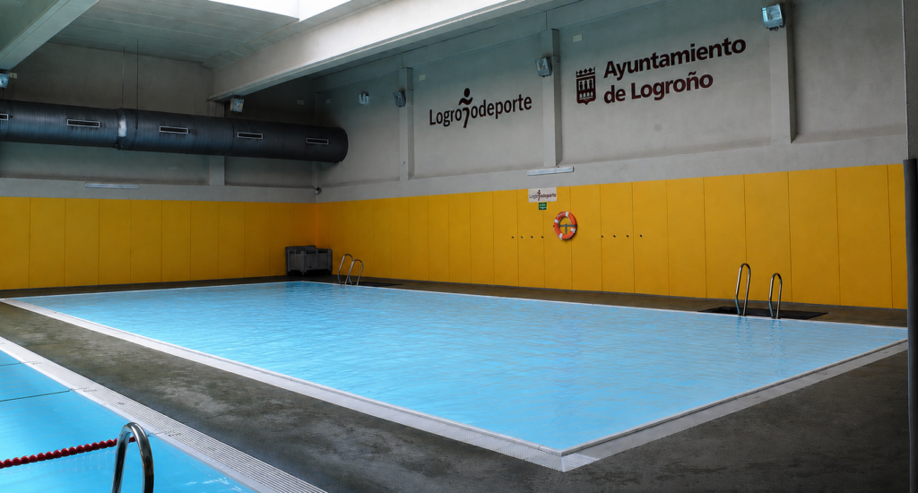 Piscina interior de competición Myrtha Pools, con pared amarilla y logo del Ayuntamiento de Logroño.