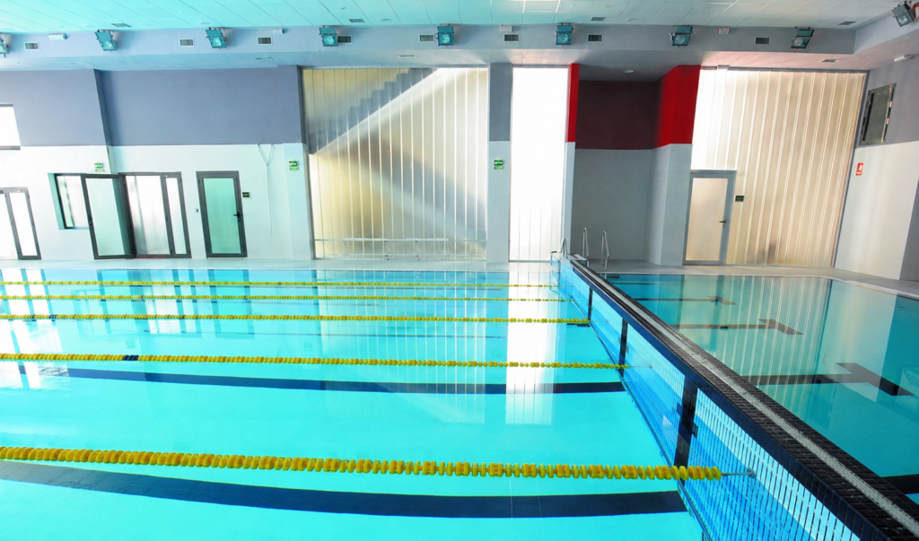 Piscina cubierta de competición con carriles de natación y escaleras