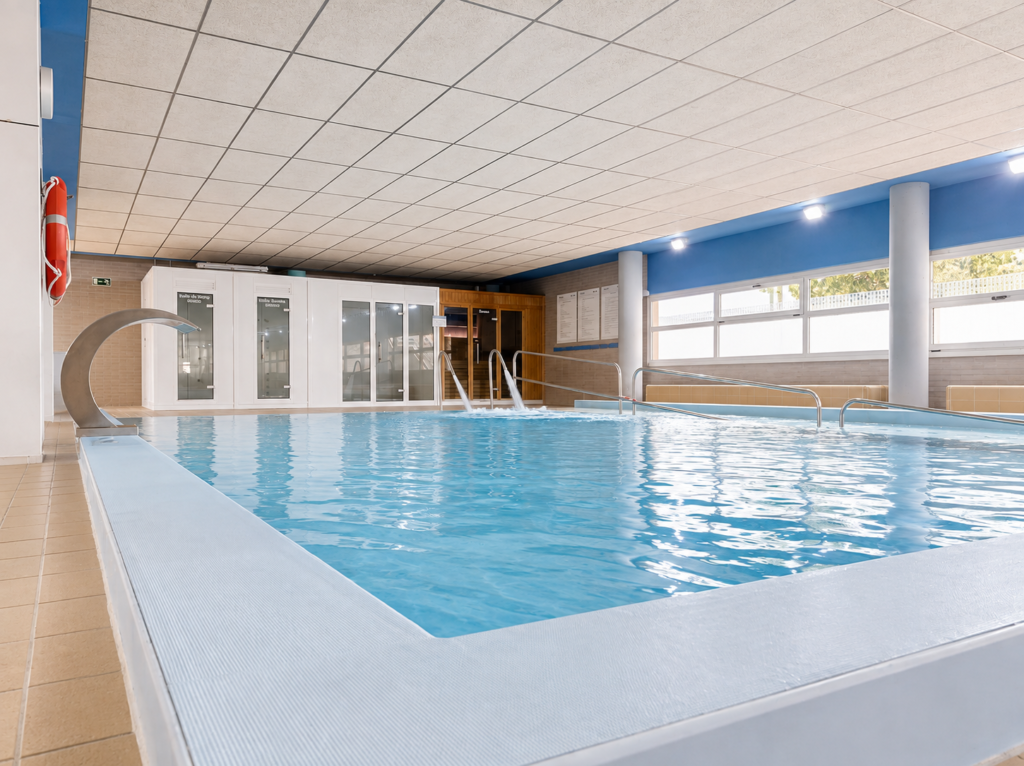 Piscina interior cubierta con cascada, parte de la renovación de piscinas en Madrid.