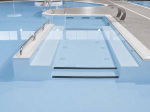 Piscina interior: escaleras de acceso y zona de spa con chorros.