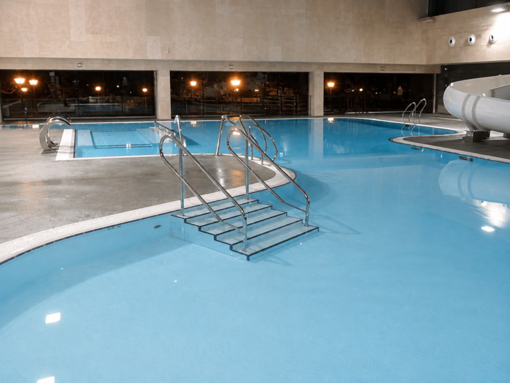 Piscina cubierta con escaleras y tobogán, lista para uso recreativo.
