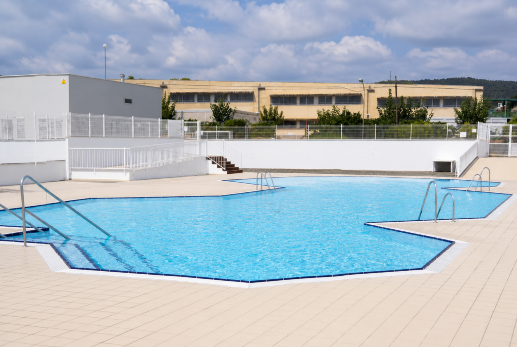 Piscina exterior Myrtha del Club Tenis El Vendrell con escaleras y bordes de baldosas.