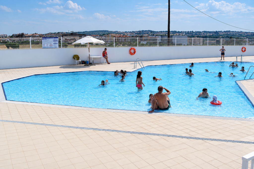 Piscina exterior recreativa Myrtha Pools con gente bañándose.