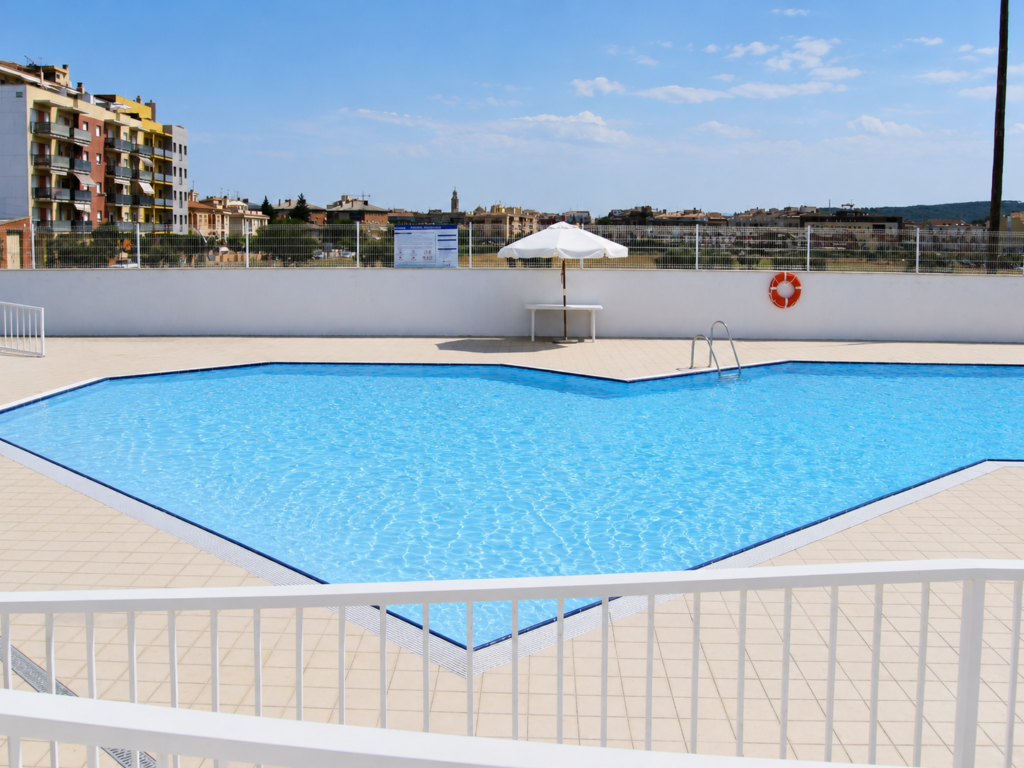 Piscina exterior de diseño Myrtha Pools para club deportivo, con tumbonas y sombrilla.