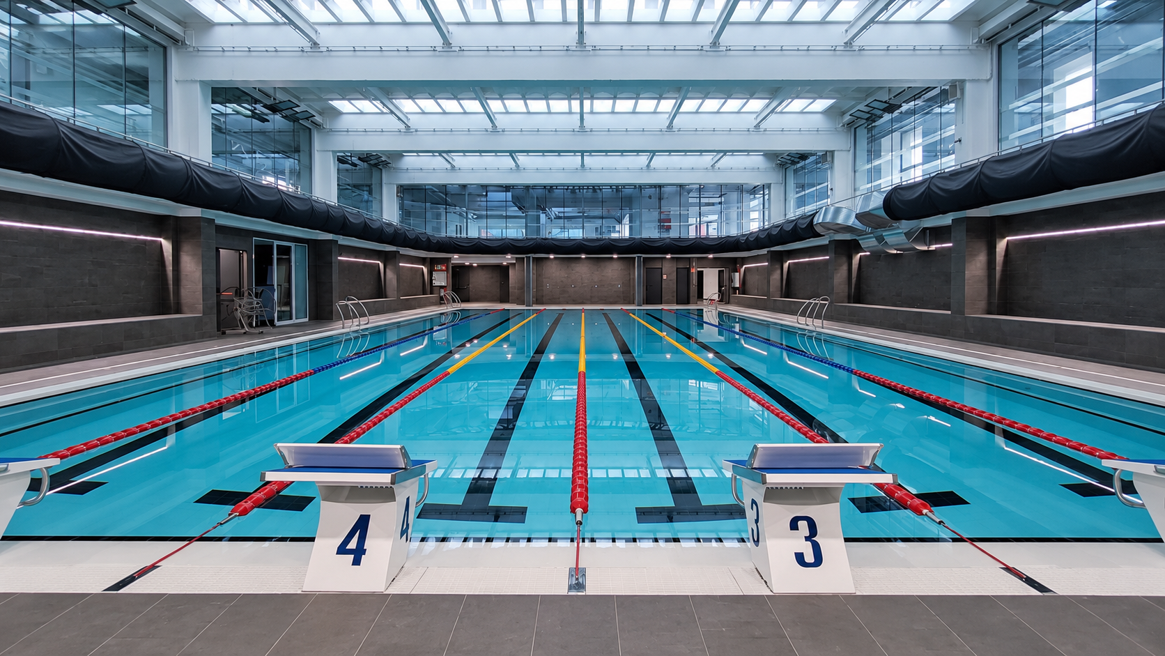 Piscina interior de competición con carriles y números 3 y 4