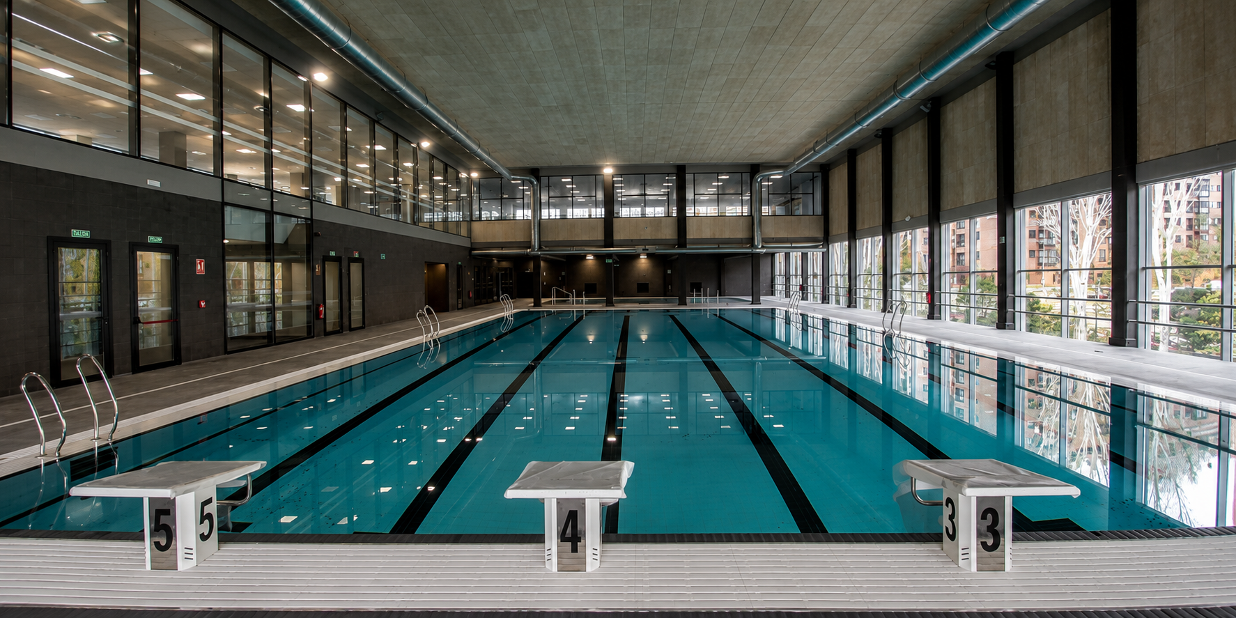 Piscina cubierta de competición renovada en Madrid, ideal para reforma de piscinas municipales.