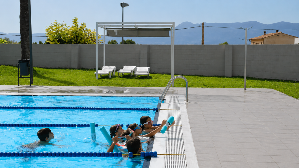 Niños practicando natación en piscina pública exterior