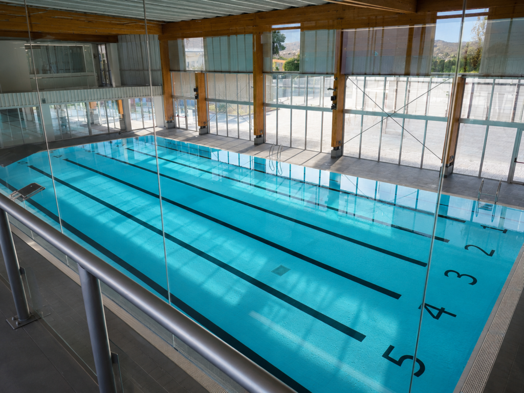 Piscina Myrtha de competición interior con carriles de natación y estructura de madera