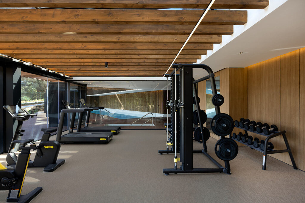 Gimnasio interior Village Verde fase II con piscina y equipamiento deportivo