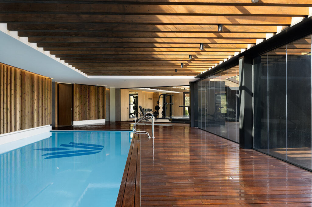 Piscina interior de diseño en Village Verde con zona de spa y gimnasio.