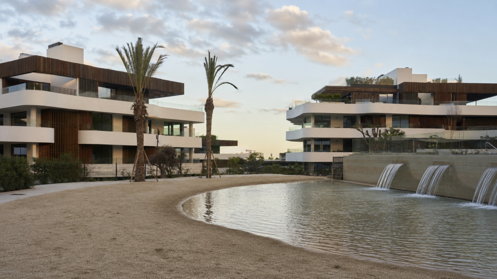Piscina exterior de diseño en Village Verde con cascadas y palmeras.