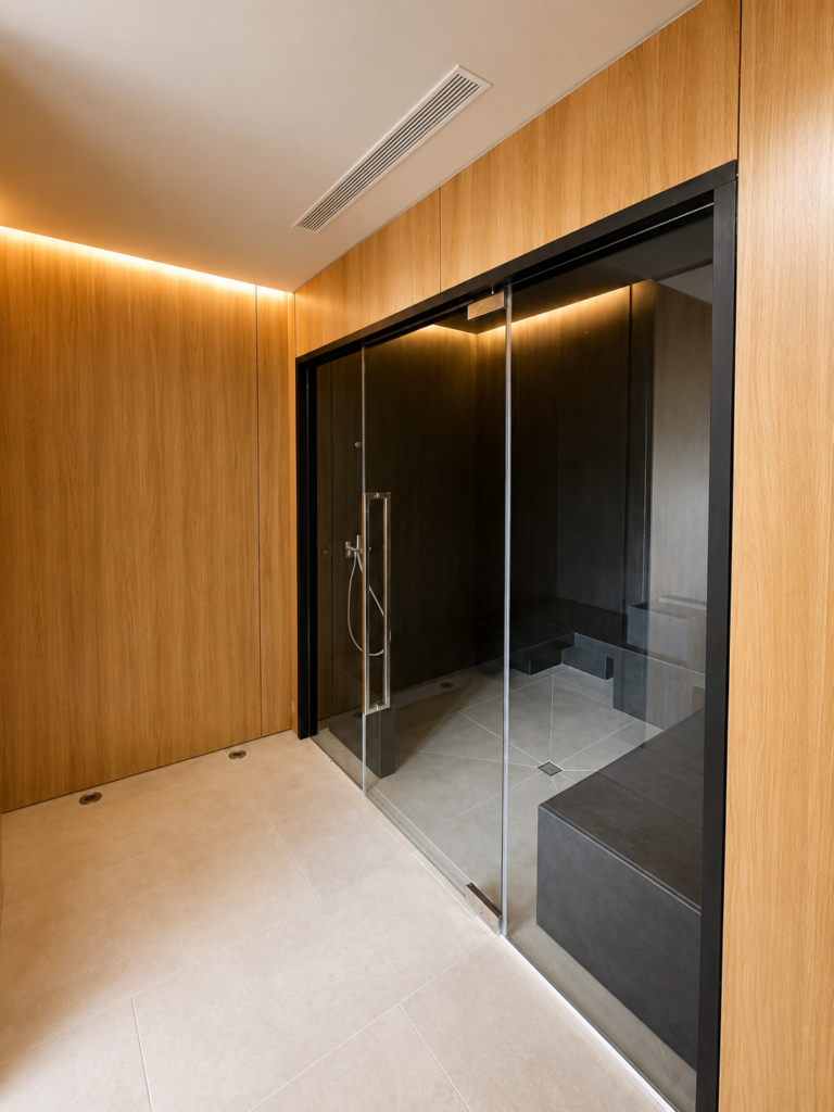 Baño de vapor de diseño moderno en Village Verde fase II con cabina de acero inox Myrtha y puerta de cristal.