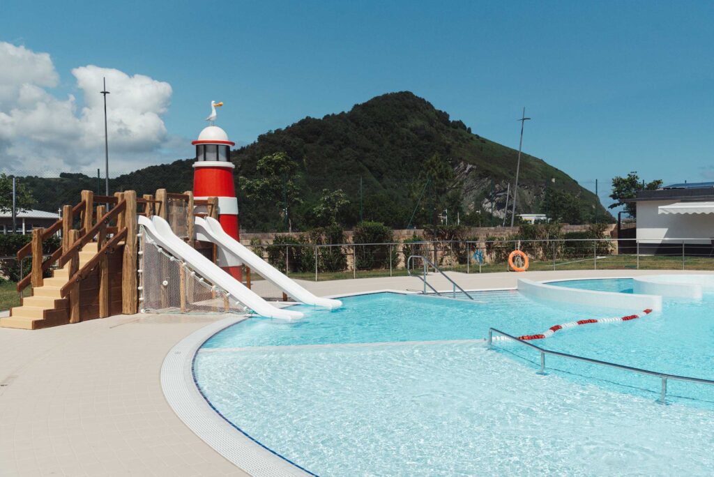 Piscina exterior recreativa con toboganes y faro en Orio Kanpina.