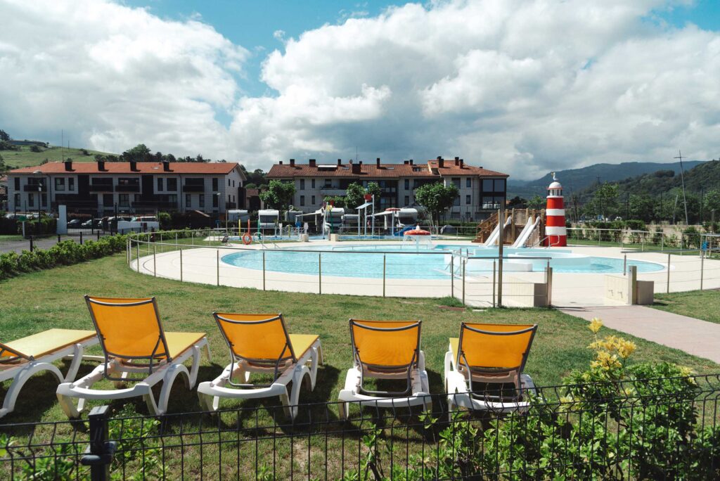 Piscinas recreativas exteriores en Orio Kanpina con tumbonas y toboganes.