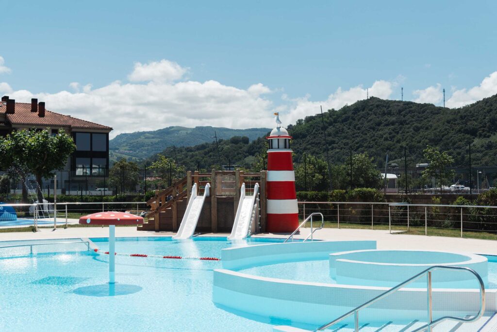 Piscinas exteriores recreativas con toboganes y faro en Orio Kanpina.