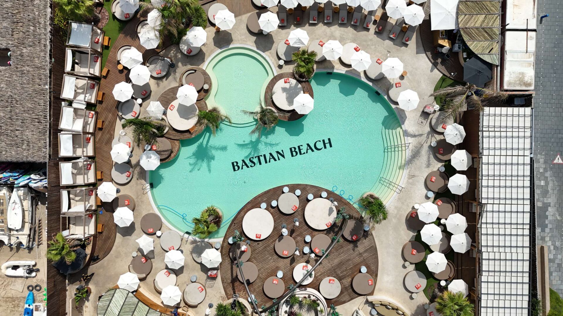 Vista aérea del Bastian Beach Club con piscina de diseño y zona lounge.
