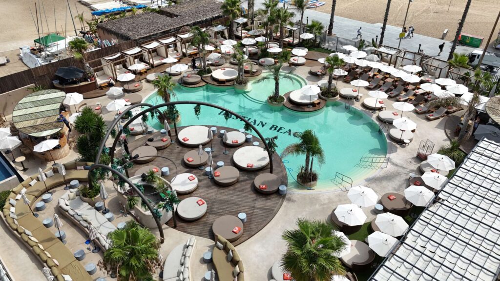 Bastian Beach Club 3 Bastian Beach Club: piscina de diseño exterior con tumbonas y palmeras.