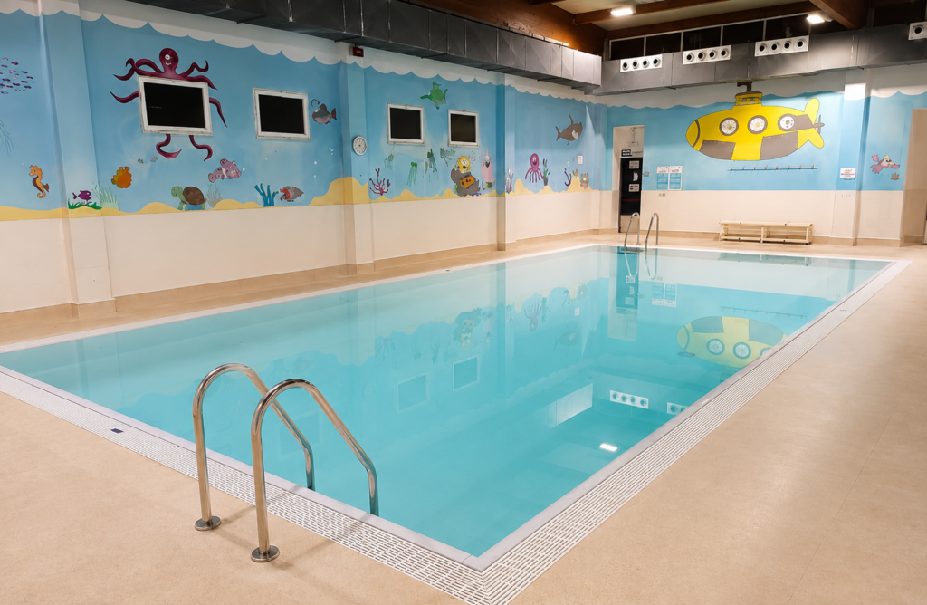 Piscina interior recreativa Alpe Pools, murales infantiles.