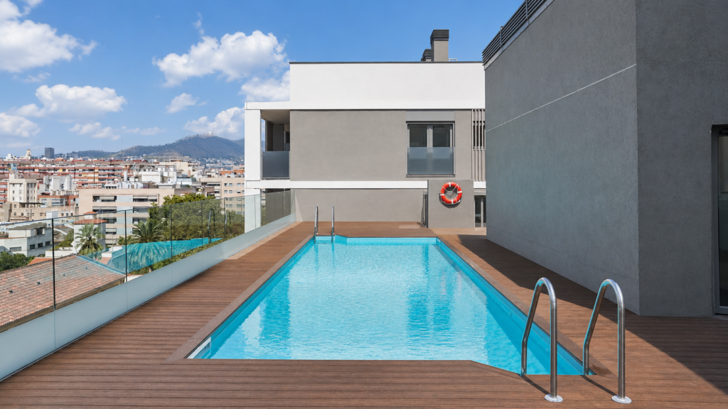 Culmia Themis Riera 4 Piscina de diseño exterior en Barcelona, con cubierta de madera y vistas a la ciudad.