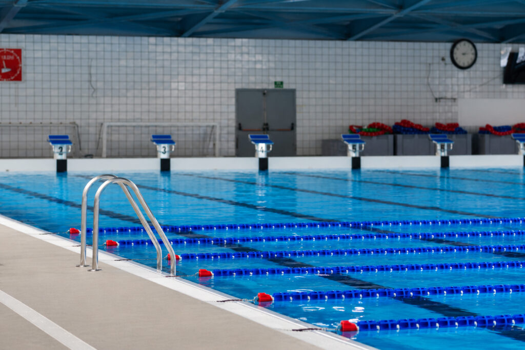 Piscina cubierta de competición en Molins de Rei con carriles de natación y escaleras.