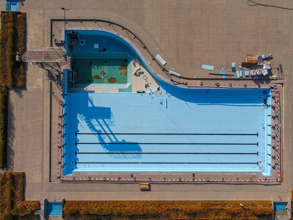 Piscina de competición Myrtha Pools en renovación, con carriles de natación y plataforma de saltos.